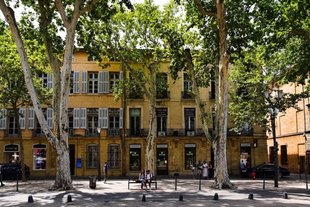Façades provençales aux volets clairs bordées de platanes dans le centre d'Aix-en-Provence