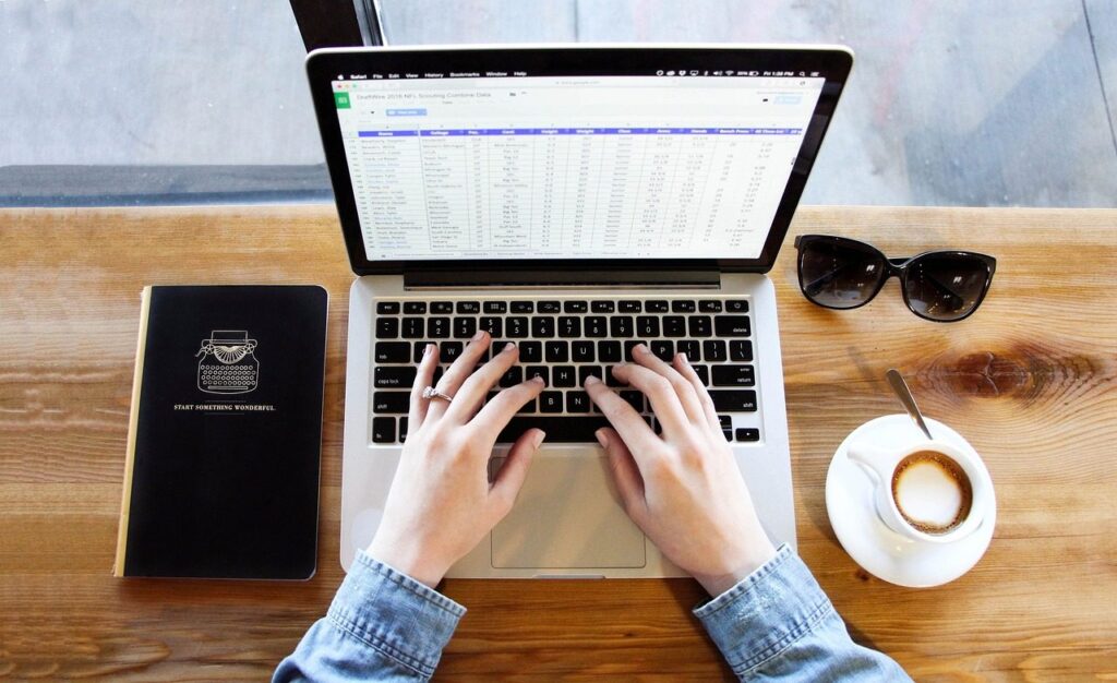 Tableur ouvert sur un ordinateur portable posé sur un bureau en bois