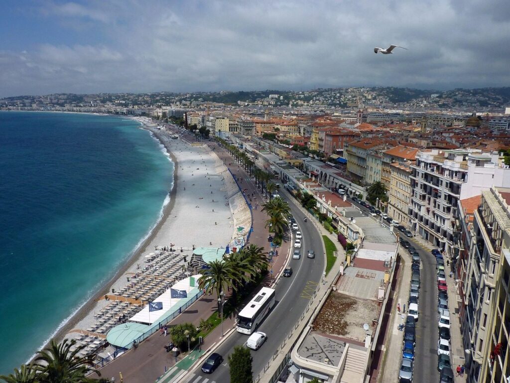 Vue en hauteur de la promenade des Anglais à Nice, avec la plage, la baie et les immeubles du front de mer